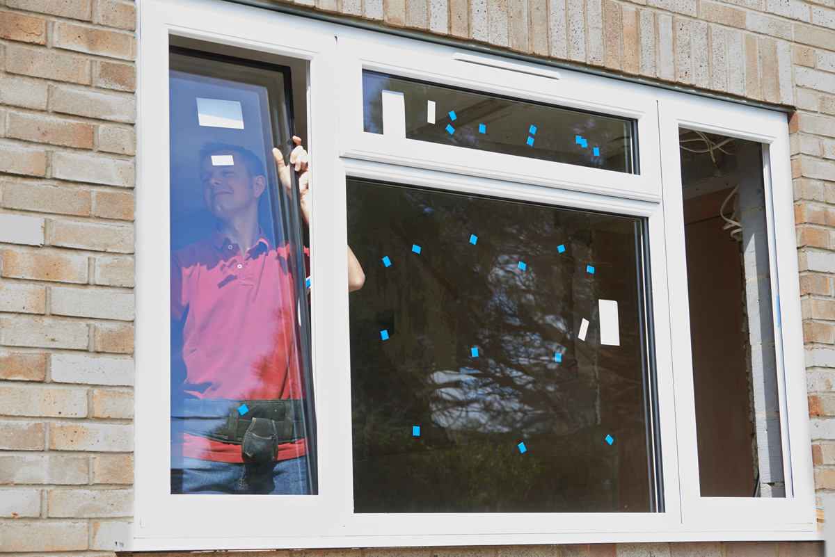 A person inside a Euclid home installing energy efficient windows.
