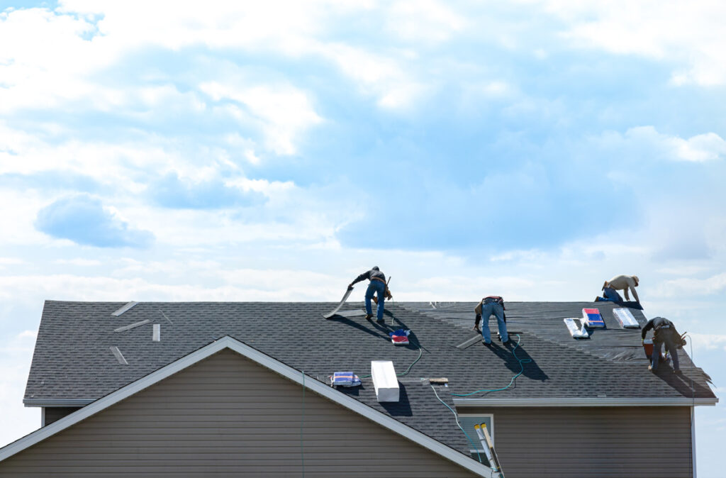 Four people doing a roof repair on a Euclid home.
